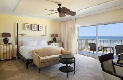 Kahala Hotel & Resort gay-friendly room. Ocean view from balcony. King bed, sofa, ceiling fan. Upscale, luxury travel for gay men.