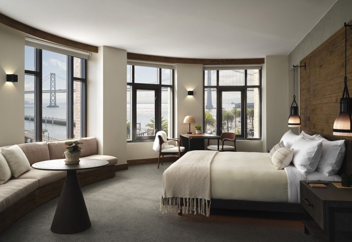 1 Hotel San Francisco room. Gay-friendly hotel with bay bridge views, desk, bed, and seating area. Modern interior design.