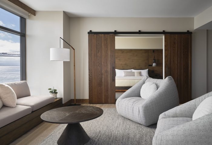 1 Hotel San Francisco room. Gay-friendly hotel featuring modern design, sliding wood doors, bay view, and comfortable seating.
