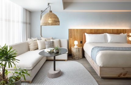 1 Hotel Toronto: Gay-friendly hotel room with a bed, couch, and unique lighting. A stylish, welcoming space for gay travelers. #TorontoHotel