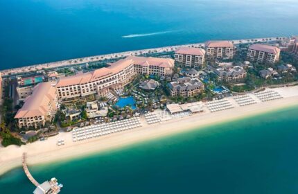 Aerial view of Sofitel Dubai The Palm Resort & Spa, a gay-friendly hotel. Beachfront property with pools, palm trees, and ocean views.