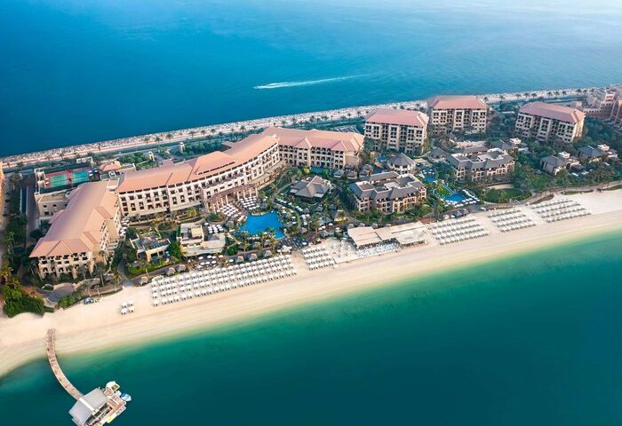 Aerial view of Sofitel Dubai The Palm Resort & Spa, a gay-friendly hotel. Beachfront property with pools, palm trees, and ocean views.