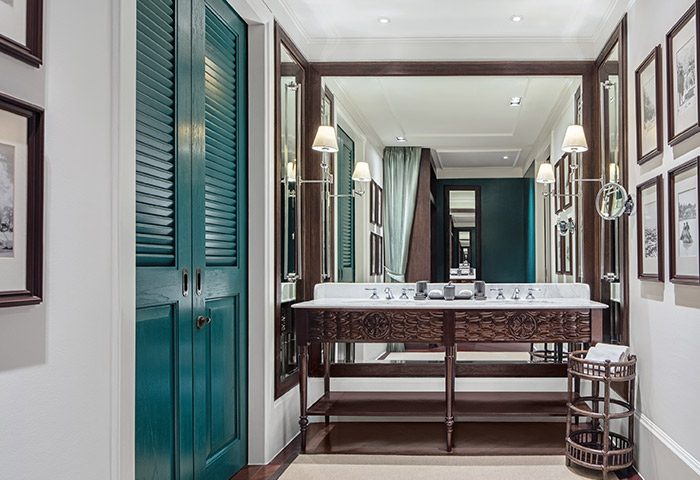 Bathroom at 137 Pillars House Chiang Mai, a gay-friendly hotel. Features a double vanity, teal shutters, & framed art. Luxury travel.