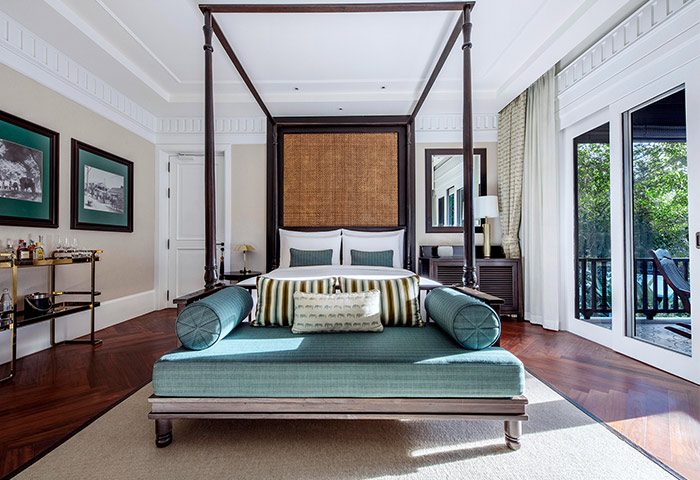 137 Pillars House Chiang Mai suite. Gay-friendly hotel room with a four-poster bed, daybed, and balcony. Luxury travel in Thailand.