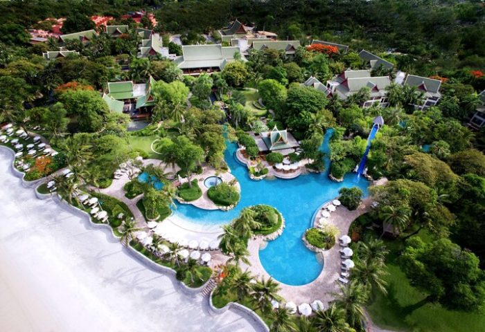 Aerial view of The Barai By Hyatt, a gay-friendly hotel. Pools, lush gardens, beach, and Thai-style architecture create a luxurious resort experience.