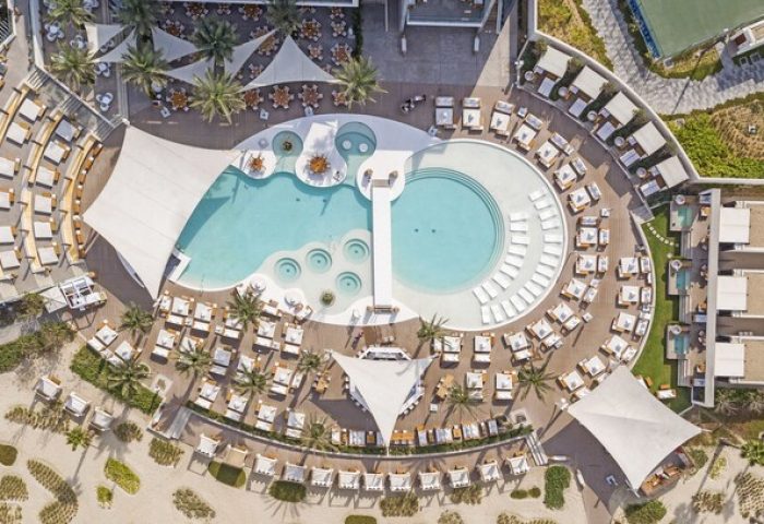 Aerial view of Nikki Beach Resort & Spa Dubai, a gay-friendly hotel. Pools, cabanas, and lounge areas offer luxury for gay travelers.