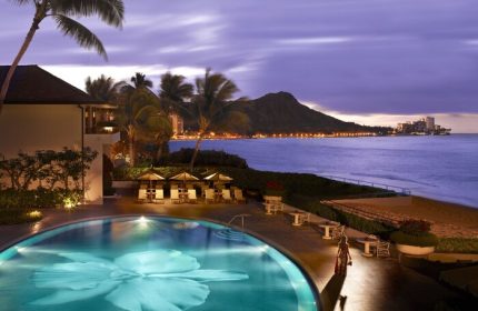 Halekulani Hotel pool at dusk. Gay-friendly hotel with Diamond Head view. Luxury travel for gay men in Hawaii. Oceanfront resort.