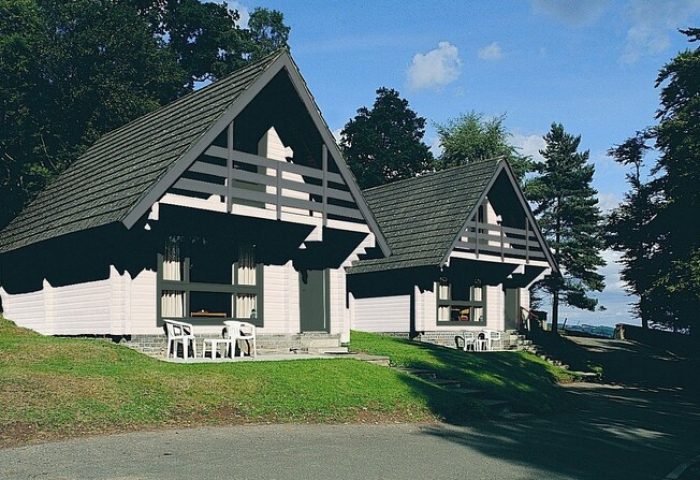 Crieff Hydro, a gay-friendly hotel. Two chalets with A-frame roofs, set on a grassy hill. A great option for gay men's travel.