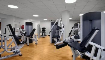 Sheraton Waikiki Beach Resort's gym. A gay-friendly hotel with modern exercise machines on a wood floor. Fitness center for gay men's travel.