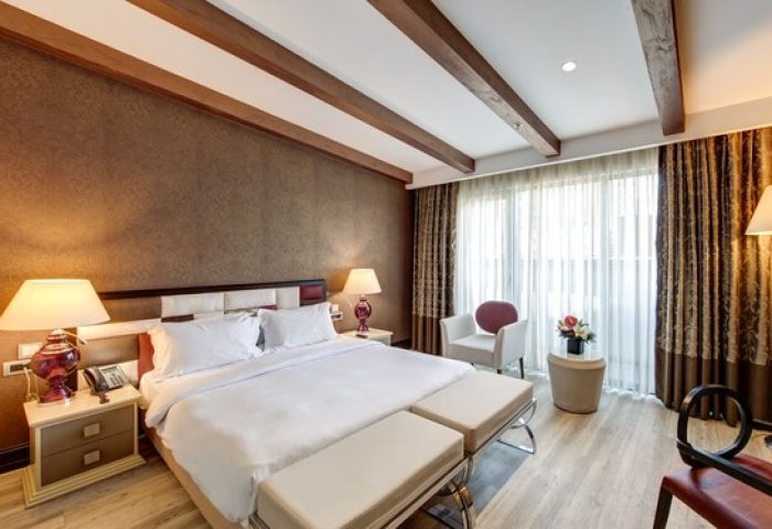 Elysium Taksim Hotel room. Gay-friendly hotel with a king bed, wooden beams, and stylish decor. Ideal for gay travel in Istanbul.