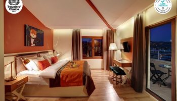 The Fox Hotel room with balcony. Gay-friendly hotel with orange accents, a fox art piece, and city views. Safe Tourism certified.
