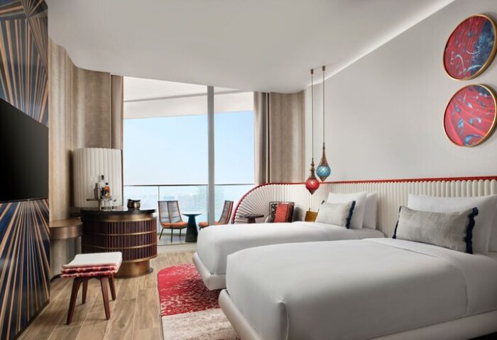 W Dubai - Mina Seyahi gay-friendly hotel room with two beds, balcony, modern decor, and city view. Luxury travel for gay men in Dubai.
