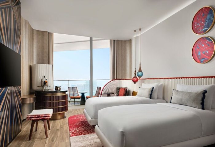 W Dubai - Mina Seyahi gay-friendly hotel room with two beds, balcony, modern decor, and city view. Luxury travel for gay men in Dubai.