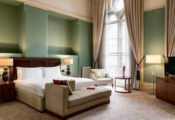 St. Pancras Renaissance Hotel London gay-friendly room. Elegant bedroom with large window and seating area. Luxury gay travel in London.