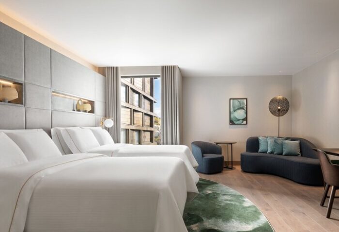 The Westin London City gay-friendly hotel room. Twin beds, sofa, and city view. Modern, stylish interior for gay men travel advice.