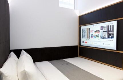 The Z Hotel Covent Garden room. Gay-friendly hotel with a bed, pillows, a TV, and a modern design. Ideal for gay men travel in London.