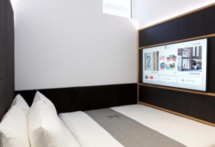 The Z Hotel Covent Garden room. Gay-friendly hotel with a bed, pillows, a TV, and a modern design. Ideal for gay men travel in London.