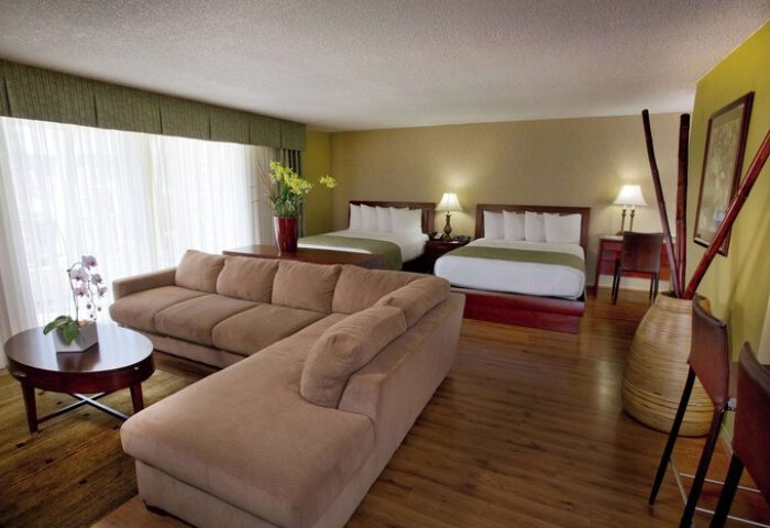 Ramada Plaza by Wyndham Waikiki gay-friendly hotel room. Two beds, couch, table, and chairs. Great for gay men travel to Honolulu.