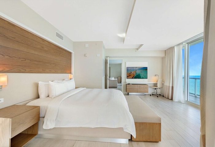 Hilton Fort Lauderdale Beach Resort gay-friendly hotel room. Ocean view from balcony, king bed, desk, and TV. Modern, light-filled interior.