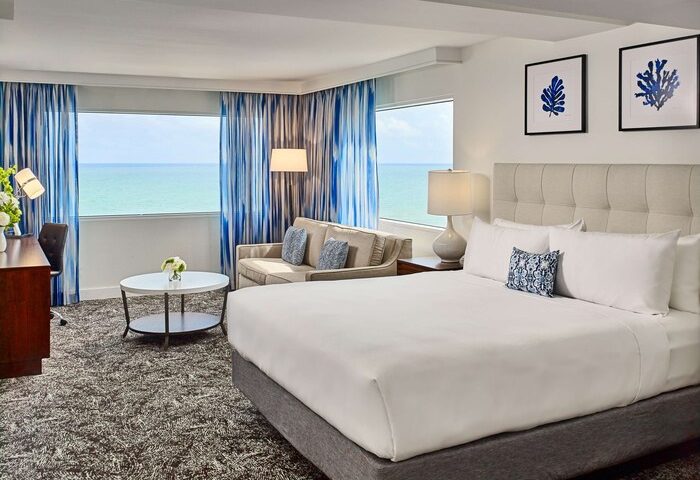 Sonesta Fort Lauderdale Beach gay-friendly hotel room with ocean view. Modern decor, king bed, sofa, desk. Perfect for gay travel.