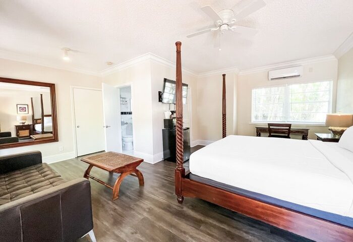 La Casa Hotel room: bed, couch, desk, & bath. Gay-friendly hotel with modern decor, wood floors, & natural light. Perfect for gay men travel.