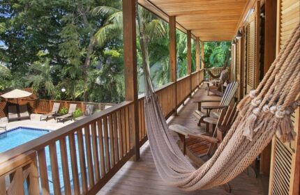 Island City House gay-friendly hotel balcony view. Hammock, wooden chairs, and pool. Tropical getaway for gay men. Relaxing vacation.
