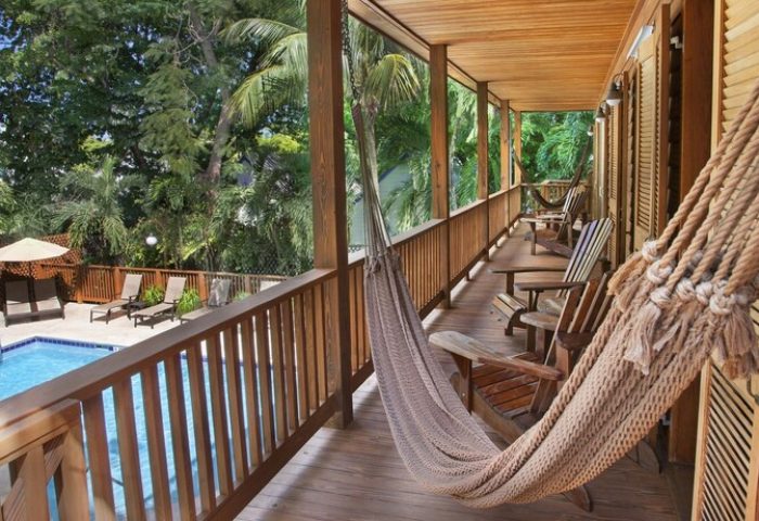 Island City House gay-friendly hotel balcony view. Hammock, wooden chairs, and pool. Tropical getaway for gay men. Relaxing vacation.