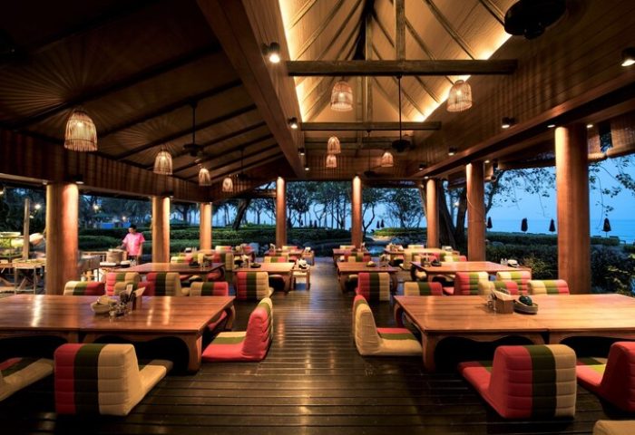 The Barai Hyatt's gay-friendly hotel restaurant. Tables with colorful cushions on a wooden floor and open view to the beach.