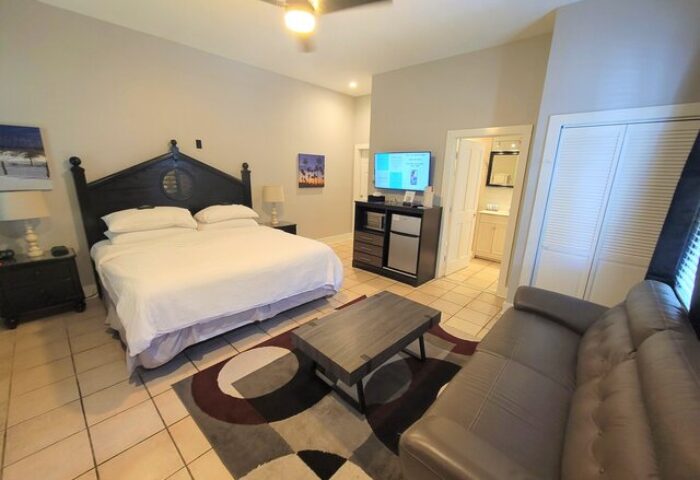 Equator Resort gay-friendly hotel room. King bed, sofa, TV, and bathroom. Great gay travel lodging option.