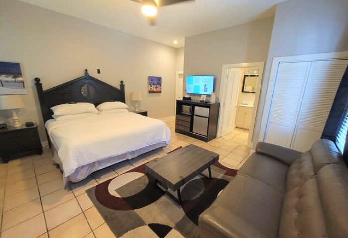 Equator Resort gay-friendly hotel room. King bed, sofa, TV, and bathroom. Great gay travel lodging option.