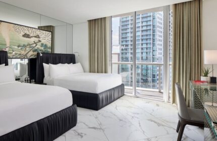W Miami gay-friendly hotel room. Two beds, city view, desk, and modern decor. Ideal for gay men's travel. Luxury and comfort combined.
