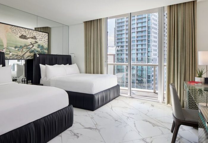 W Miami gay-friendly hotel room. Two beds, city view, desk, and modern decor. Ideal for gay men's travel. Luxury and comfort combined.