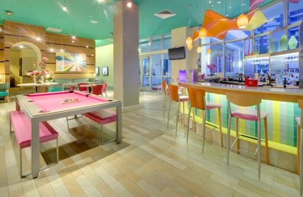 Hampton Inn & Suites Miami/Brickell-Downtown gay-friendly hotel bar and lounge area. Pink pool table and colorful decor. Gay travel advice.