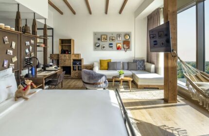 25hours Hotel One Central gay-friendly room. Modern design, desk, hammock, and city view. Ideal for gay men travel. Stylish, comfortable stay.