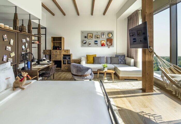 25hours Hotel One Central gay-friendly room. Modern design, desk, hammock, and city view. Ideal for gay men travel. Stylish, comfortable stay.