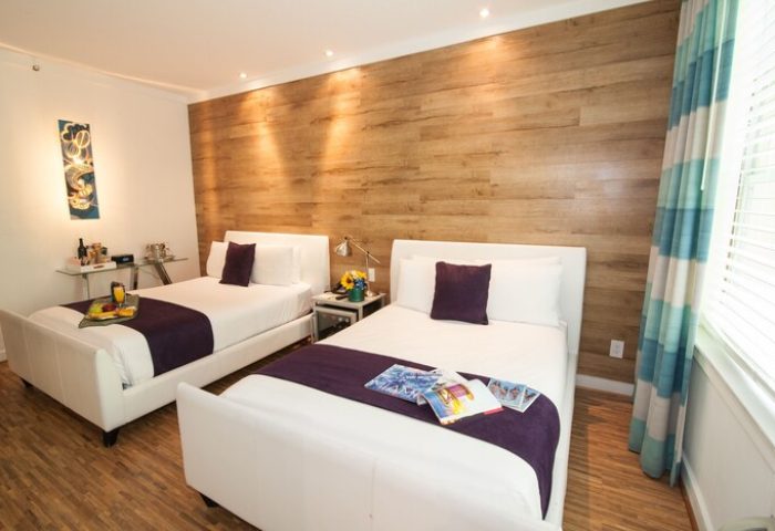 Hotel Shelley gay-friendly hotel room with two beds, wood-look accent wall, and modern decor. Ideal for gay men's travel, vacation, or getaway.