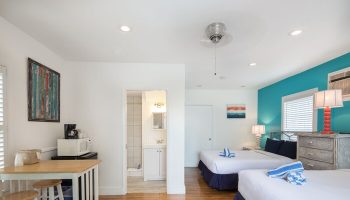 Wicker Guesthouse room with two beds, kitchenette, and bathroom. Gay-friendly hotel with bright, modern decor. Ideal for gay men travel.