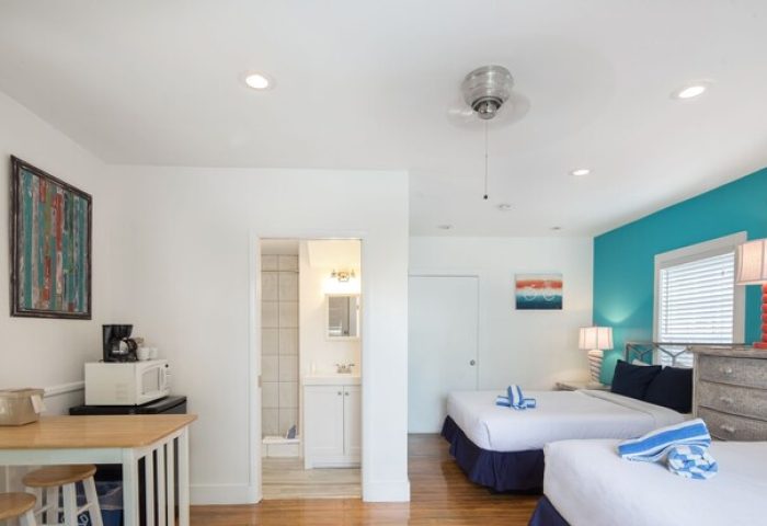 Wicker Guesthouse room with two beds, kitchenette, and bathroom. Gay-friendly hotel with bright, modern decor. Ideal for gay men travel.