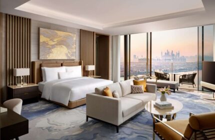 Atlantis The Royal gay-friendly hotel room. Dubai skyline view from suite. Luxury travel for gay men. Hotel bedroom with king bed and sofa.