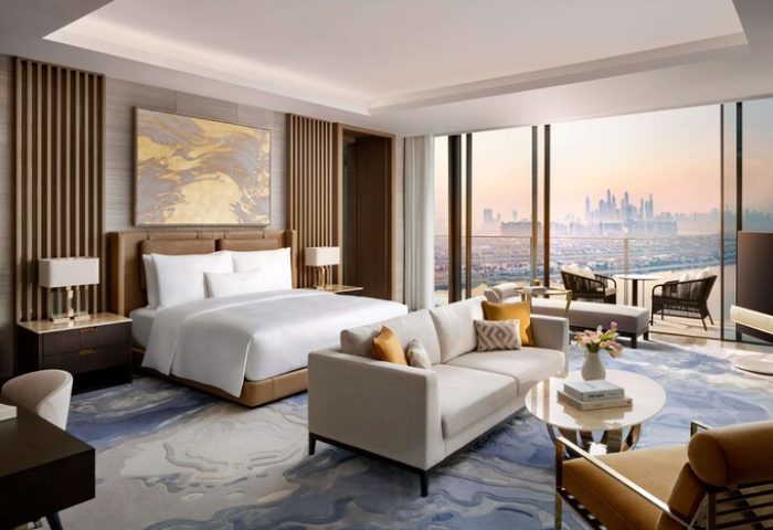Atlantis The Royal gay-friendly hotel room. Dubai skyline view from suite. Luxury travel for gay men. Hotel bedroom with king bed and sofa.
