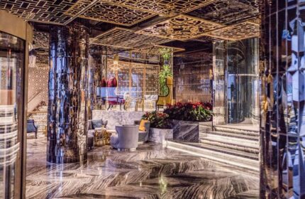 Elysium Taksim Hotel's luxurious lobby. This gay-friendly hotel features marble floors, mirrored pillars, and ornate gold ceiling designs.