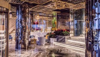 Elysium Taksim Hotel's luxurious lobby. This gay-friendly hotel features marble floors, mirrored pillars, and ornate gold ceiling designs.