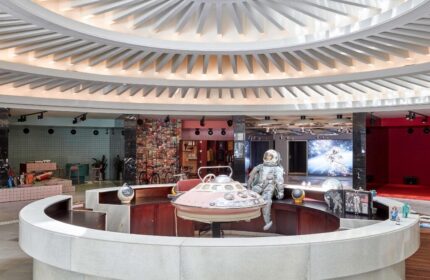 Interior of 25hours Hotel The Circle, a gay-friendly hotel. Round reception desk with astronaut figure. Unique design elements.