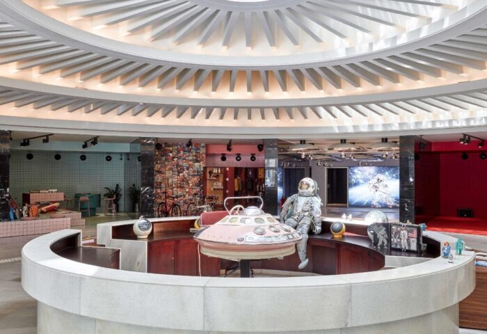 Interior of 25hours Hotel The Circle, a gay-friendly hotel. Round reception desk with astronaut figure. Unique design elements.