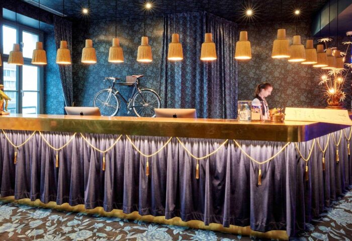 25hours Hotel The Royal Bavarian's stylish reception area. Gay-friendly hotel with unique design, bike decor, and elegant lighting.
