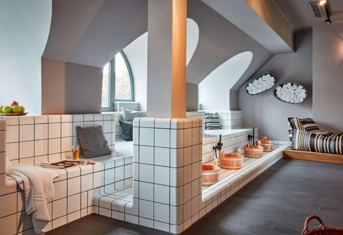 25hours Hotel The Royal Bavarian spa area. Gay-friendly hotel featuring tiled benches, wooden buckets, and unique architectural details.