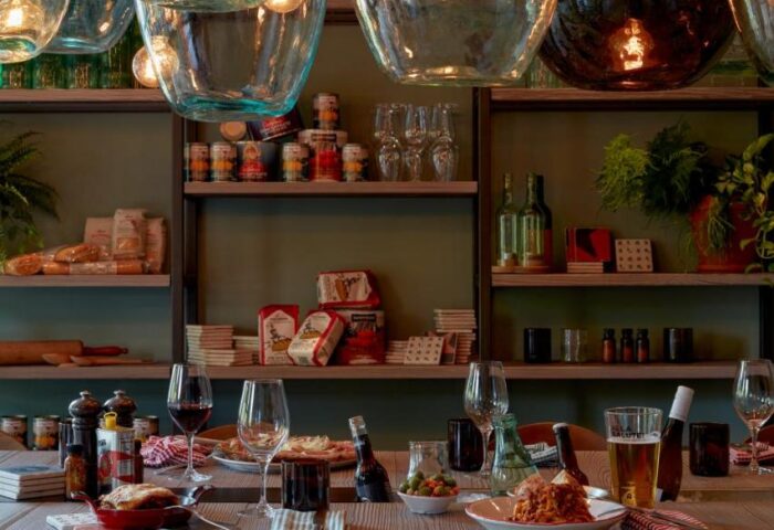 Dining at 25hours Hotel beim MuseumsQuartier, a gay-friendly hotel. Table setting with food, wine, and unique glass bottle light fixtures.