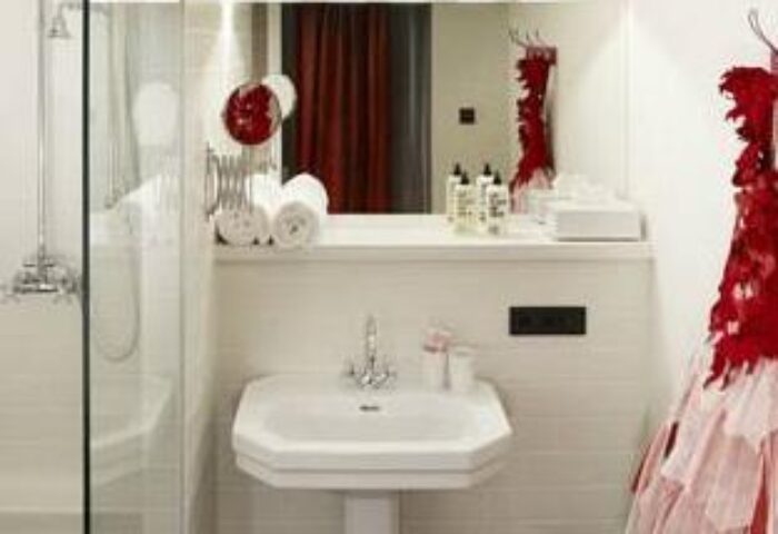 Bathroom at 25hours Hotel beim MuseumsQuartier, a gay-friendly hotel. Sink, shower, mirror, and red dress detail. Vienna travel.