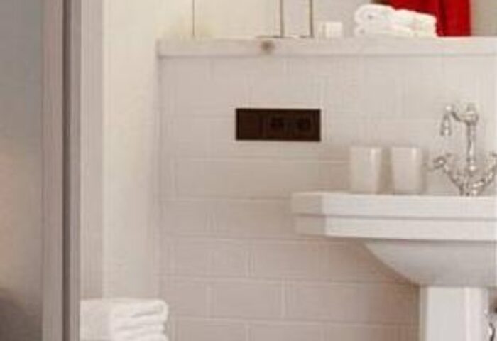 25hours Hotel beim MuseumsQuartier bathroom. Sink, white tiles, towels, and vintage-style faucet. Gay-friendly hotel in Vienna, Austria.