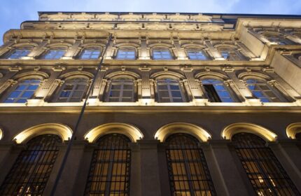 Facade of The Bank Hotel Istanbul, a Design Hotel. Arched windows with iron bars. Gay-friendly hotel architecture. Night view.